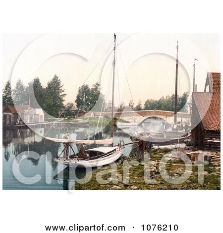 Historical Boats on the Water Near the Bridge in Wroxham Norfolk England UK - Royalty Free Stock Photography  by JVPD