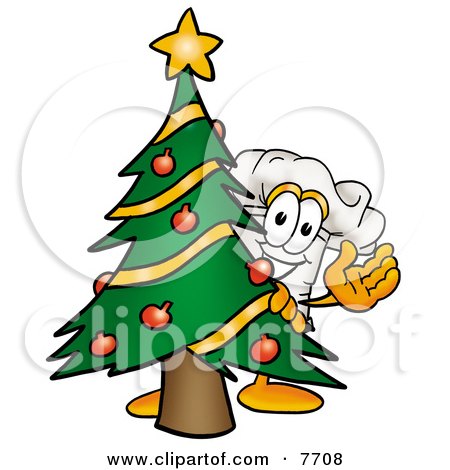 Clipart Picture of a Chefs Hat Mascot Cartoon Character Waving and Standing by a Decorated Christmas Tree by Mascot Junction