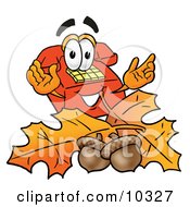 Clipart Picture Of A Red Telephone Mascot Cartoon Character With Autumn Leaves And Acorns In The Fall
