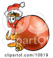 Paint Brush Mascot Cartoon Character Wearing A Santa Hat Standing With A Christmas Bauble