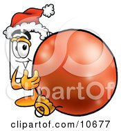 Clipart Picture Of A Paper Mascot Cartoon Character Wearing A Santa Hat Standing With A Christmas Bauble