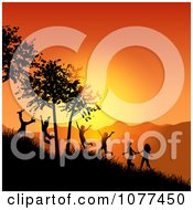 Silhouetted Children Playing On A Hillside At Sunset