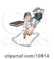 Elementary School Boy Lying On His Stomach And Doing Homework Or Drawing