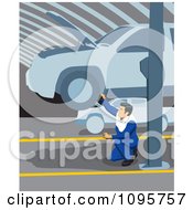 Male Mechanic Kneeling And Working Below A Car On A Lift In A Garage