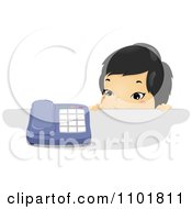 Asian Child Looking Over A Counter At A Telephone