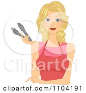 Beautiful Blond Woman In A Red Apron Pointing And Holding Tongs