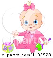 Happy Baby Girl In A Pink Sleeper With A Rattle And Toy Block