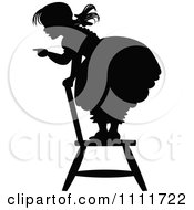 Clipart Silhouetted Girl Pointing And Standing On A Chair In Black And White Royalty Free Vector Illustration