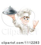 Happy Young Male Chef Holding A Platter And Gesturing Ok