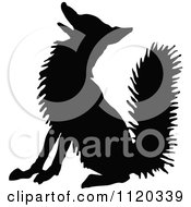 Clipart Of A Silhouetted Fox Sitting Royalty Free Vector Illustration