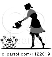 Silhouetted Woman Watering A Flower Garden