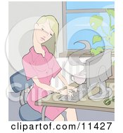 Young Blond Woman Working On A Computer At A Desk In An Office
