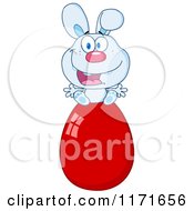 Cartoon Of A Happy Blue Easter Bunny Sitting On A Red Egg Royalty Free Vector Clipart