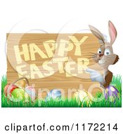 Cartoon Of A Happy Bunny Pointing To A Happy Easter Sign With A Basket And Easter Eggs In Grass Royalty Free Vector Clipart
