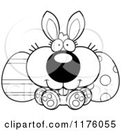 Cartoon Of A Black And White Happy Easter Bunny Sitting With Eggs Royalty Free Vector Clipart