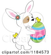 Poster, Art Print Of Cute Puppy Wearing A Bunny Costume And Carrying An Easter Egg With Chicks