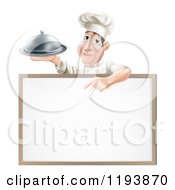 Male Chef Holding A Cloche And Pointing Down At A White Board