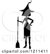 Cartoon Of A Black Silhouetted Witch With A Hand On Her Hip And A Broom Royalty Free Vector Clipart