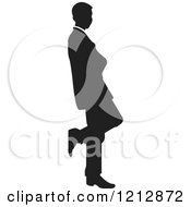 Clipart Of A Silhouetted Businessman Leaning Against A Wall Royalty Free Vector Illustration