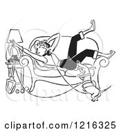 Retro Weiner Dog And Teen Girl Laying On A Couch While Talking On A Landline Telephone In Black And White