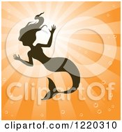 Clipart Of A Silhouetted Swimming Mermaid Over Orange Rays Royalty Free Vector Illustration