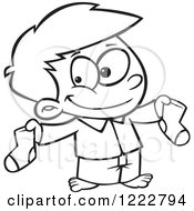 Clipart Of A Black And White Happy Little Boy Holding Up Christmas Socks Royalty Free Vector Illustration