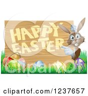 Clipart Of A Brown Bunny Pointing To A Happy Easter Sign With Easter Eggs In Grass Royalty Free Vector Illustration