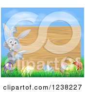 Clipart Of A Wood Sign Gray Easter Bunny With Eggs Grass And Sky Royalty Free Vector Illustration