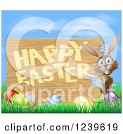 Clipart Of A Brown Bunny Pointing To A Happy Easter Sign With Easter Eggs In Grass Royalty Free Vector Illustration