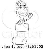 Clipart Of A Black And White Man Christmas Elf Waving In A Stocking Royalty Free Vector Illustration by Cory Thoman