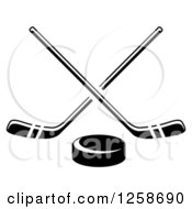 Clipart Of A Black And White Hockey Puck Under Crossed Sticks Royalty Free Vector Illustration