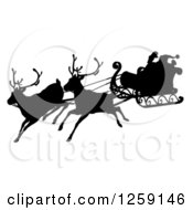 Clipart Of A Black Silhouette Of Santa Flying In A Magic Sleigh With Two Reindeer Royalty Free Vector Illustration
