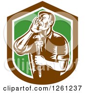 Retro Woodcut Plumber Hollering And Holding A Monkey Wrench In A Brown White And Green Shield