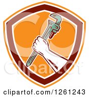 Clipart Of A Retro Woodcut Plumber Hand Holding A Monkey Wrench In An Orange Maroon And White Shield Royalty Free Vector Illustration