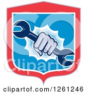 Clipart Of A Retro Cartoon Hand Breaking Through A Shield With A Spanner Wrench Royalty Free Vector Illustration