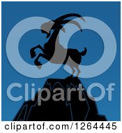 Poster, Art Print Of Silhouetted Rearing Rearing Buck Goat On A Mountain Peak Over Blue