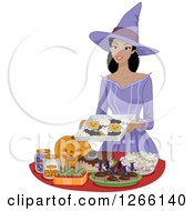 Pretty Young Black Woman Dressed As A Witch Setting Up Halloween Party Snacks