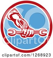 Clipart Of A Retro Strong Mechanic Hand Holding A Wrench In A Red White And Blue Circle Royalty Free Vector Illustration