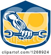 Poster, Art Print Of Retro Strong Mechanic Hand Holding A Wrench In A Blue White And Yellow Shield