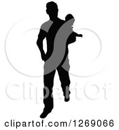 Clipart Of A Black Silhouette Of A Father Walking And Carrying A Baby Royalty Free Vector Illustration by Pushkin