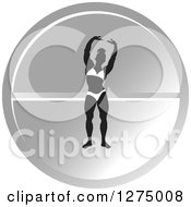 Silhouetted Female Bodybuilder Stretching Over A Round Silver Pill