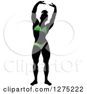 Clipart Of A Silhouetted Stretching Female Bodybuilder In A Green Suit Royalty Free Vector Illustration