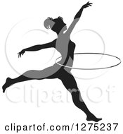 Clipart Of A Black And White Silhouetted Acrobatic Woman Leaping With A Hoop Royalty Free Vector Illustration