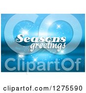 Clipart Of White Seasons Greeting Text Over A Blurred Blue Landscape With Sparkles Royalty Free Vector Illustration