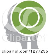 Clipart Of A Gray Silhouetted Womans Head In Profile With A Green Magnifying Glass Royalty Free Vector Illustration