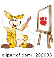 Poster, Art Print Of Happy Kangaroo School Mascot Character Painting A Paw Print On An Art Canvas