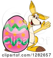 Happy Kangaroo School Mascot Character Waving By A Giant Easter Egg