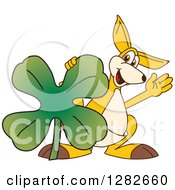 Clipart Of A Happy Kangaroo School Mascot Character Leaning On A St Patricks Day Four Leaf Clover Shamrock Royalty Free Vector Illustration by Toons4Biz