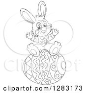 Clipart Of A Happy Black And White Easter Bunny Rabbit Cheering On A Giant Egg Royalty Free Vector Illustration
