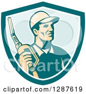 Clipart Of A Retro Gas Station Attendant Jockey Holding A Nozzle In A Turquoise White And Blue Shield Royalty Free Vector Illustration by patrimonio